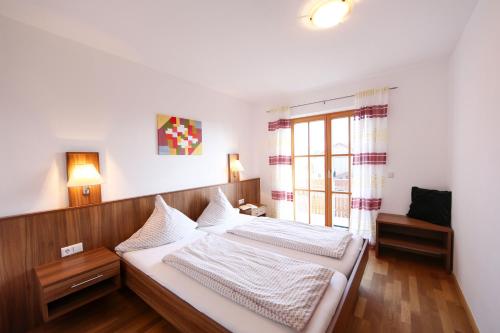 1 dormitorio con 2 camas y ventana en Ferienwohnungen auf dem Paulbauernhof en Triebenbach