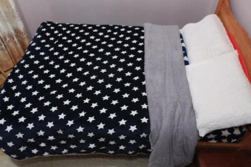 a black and white blanket with white stars on it at Chaka Furnished Apartments in Kiganjo