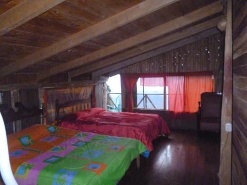 a bedroom with a bed with a red blanket at Lagunillas Del Poas in Poasito