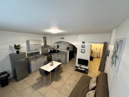 un salon et une cuisine avec un canapé et une table dans l'établissement F1 rez de chaussée au cœur de Pont-Saint Esprit, à Pont-Saint-Esprit