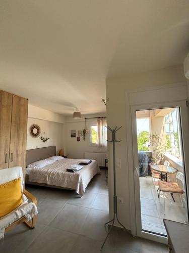 Schlafzimmer mit einem Bett und einer Glasschiebetür in der Unterkunft Liakada Guest House in Artemida