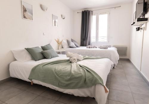2 łóżka w pokoju z białymi ścianami w obiekcie Cosy Appartement - 4 personnes - Disneyland & Paris w mieście Bussy-Saint-Georges