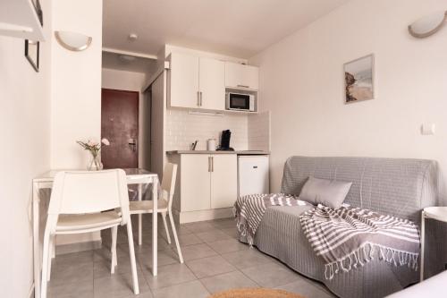 salon z kanapą i stołem oraz kuchnia w obiekcie Cosy Appartement - 4 personnes - Disneyland & Paris w mieście Bussy-Saint-Georges