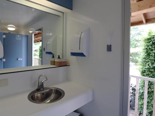 een badkamer met een wastafel en een spiegel bij Beautiful safari tent in Twijzel with terrace in Twijzel