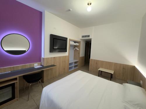 a bedroom with a white bed and a purple wall at Hotel Holidays in Roccaraso