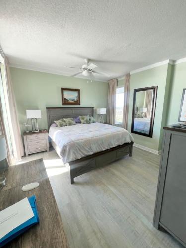 a bedroom with a large bed with a ceiling fan at Just Beachy Get-away in Biloxi