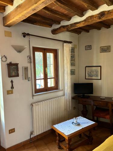 sala de estar con mesa y ventana en Da Giovannina en Buti