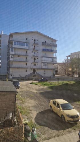 a car parked in a parking lot in front of a building at BIANCA Studio Eforie Nord in Eforie Nord