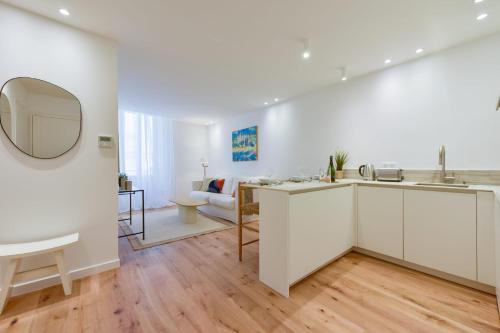 une cuisine et un salon avec des armoires blanches et un miroir dans l'établissement Upscale 1-Br apartment 100 meter from the Palais des Festivals, à Cannes