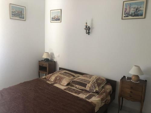 une chambre avec un lit avec deux tables de nuit et deux lampes dans l'établissement LOCATION BANYULS SUR MER les Terrasses du centre appt 4 à 6 personnes, à Banyuls-sur-Mer