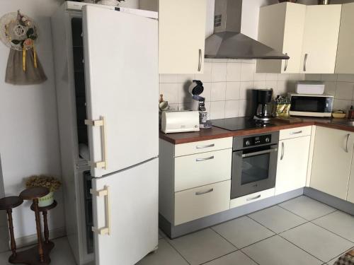 une cuisine avec des armoires blanches et un réfrigérateur blanc dans l'établissement LOCATION BANYULS SUR MER les Terrasses du centre appt 4 à 6 personnes, à Banyuls-sur-Mer