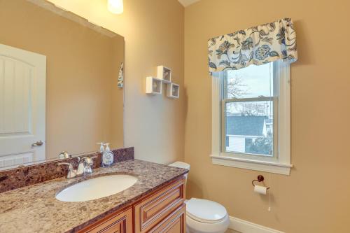 a bathroom with a sink and a toilet and a window at Long Beach Island Townhome with Rooftop Deck! in Long Beach