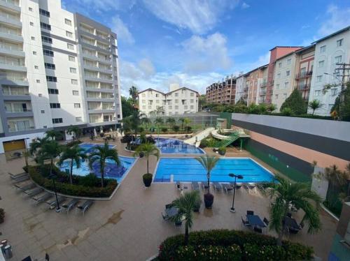 un complexe d'appartements avec 2 piscines, des palmiers et des bâtiments dans l'établissement Flat 120 / Veredas / 300m2 HotPark, à Rio Quente
