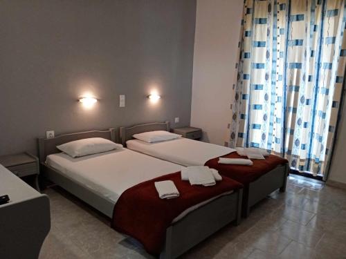 duas camas num quarto de hotel com toalhas em Dennis Apartments em Kalamaki