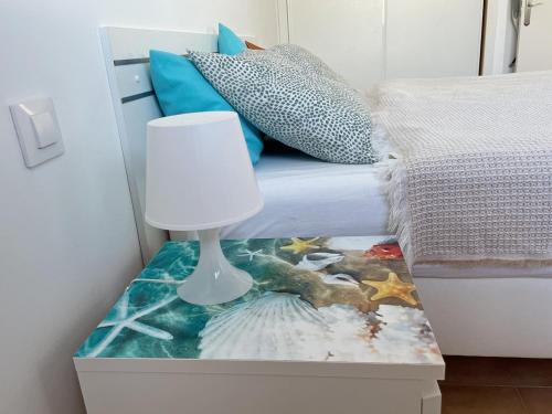 a table with a lamp next to a bed at Apartamento Vilem & Piscina, Wi-Fi in Costa Calma