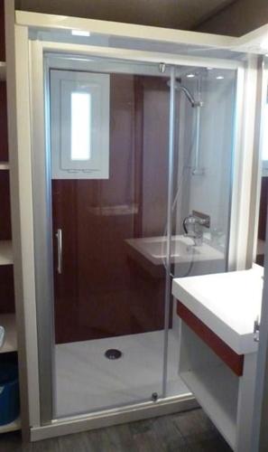 a shower with a glass door next to a sink at Chalet JACUZZI/spa privatif PERCE NEIGE in Plombières-les-Bains