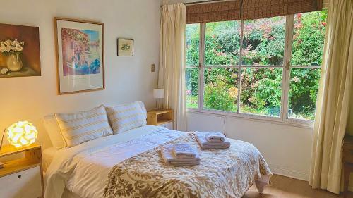 a bedroom with a bed and a large window at Casita excelente ubicación in San Carlos de Bariloche