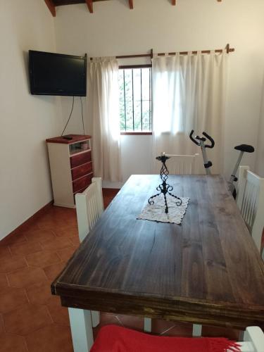 蒙特格蘭德的住宿－Casa Valeria, Ezeiza，一间带木桌和电视的用餐室