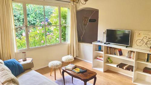 a living room with a couch and a tv at Casita excelente ubicación in San Carlos de Bariloche