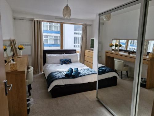 Luxury Modern Central London - London Bridge - Westminster - 2 Bed Stylish Apartment في لندن: غرفة نوم مع سرير مع مكتب ومرآة