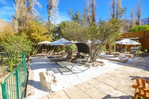 a patio with a bunch of chairs and umbrellas at Hotel El Tesoro de Elqui in Pisco Elqui