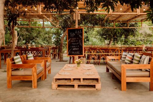 a restaurant with wooden tables and chairs and a chalkboard at Hotel Fundo El Arrabal in Ica