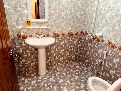 La salle de bains est pourvue d'un lavabo et de toilettes. dans l'établissement Sweet Homes Apartments, à Lahore