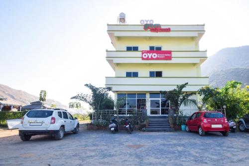 um edifício com dois carros estacionados em frente em OYO Green Valley Resort em Pushkar