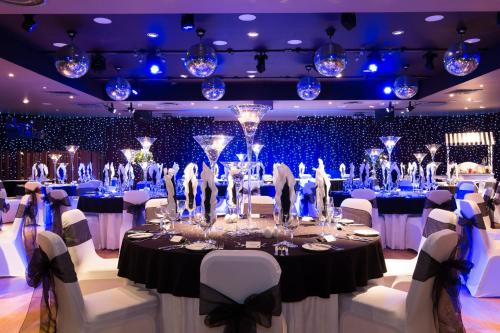 a ballroom with a table with white chairs and blue lights at Holiday Inn Aberdeen West by IHG in Westhill 