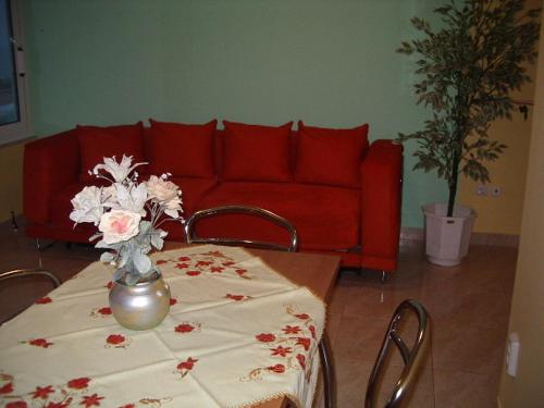 a living room with a table and a red couch at Hotel Dias Apartment in Makrýgialos