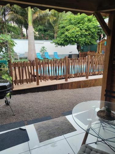 eine Terrasse mit einem Zaun, Stühlen und einem Tisch in der Unterkunft GWADA FUN HABITATION in Saint-Claude