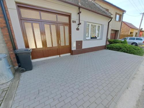 a house with a garage door and a trash can at Karolinka Radějov in Radějov