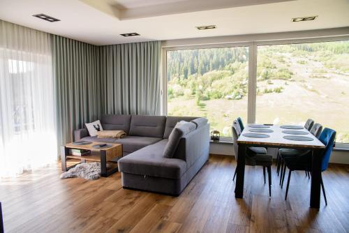 - un salon avec un canapé et une table dans l'établissement Apartamenty TRIO, à Muszyna