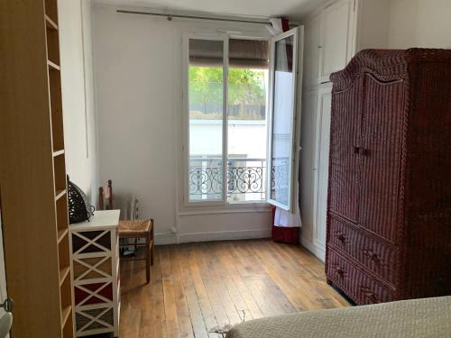 une chambre avec une fenêtre et une commode dans l'établissement Paris- Charonne, à Paris