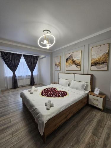- une chambre avec un grand lit et une couverture rouge dans l'établissement LUXE APARTMENTS, à Almaty