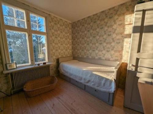 1 dormitorio pequeño con 1 cama y 2 ventanas en Hus i Edane, en Edane