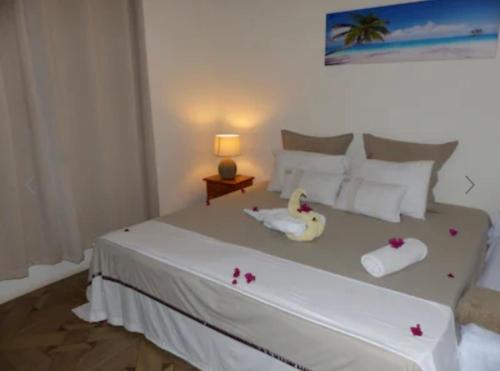 a bedroom with a white bed with flowers on it at Beehive in Pamplemousses Village