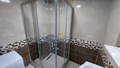 La salle de bains est pourvue d'une douche avec une porte en verre. dans l'établissement HOPE Apartment, à Vodno