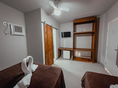 a room with a bed and a television and a window at Pousada Porto Girassol in Abraão