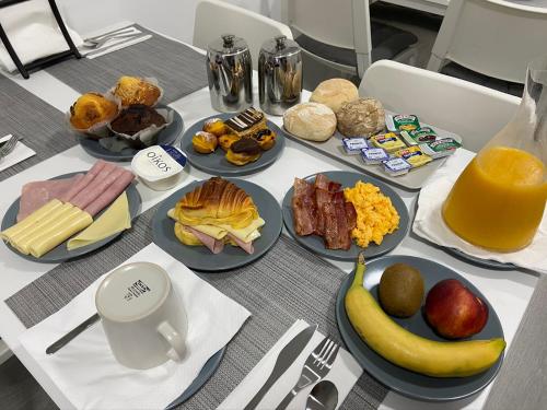 een tafel met borden ontbijtproducten erop bij Guest House Triunfo in Porto