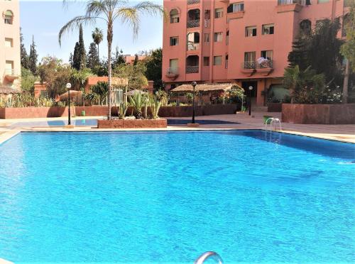 duży niebieski basen przed niektórymi budynkami w obiekcie ☆HIVERNAGE☆ Charming , Spacious & Bright with Pool w Marakeszu