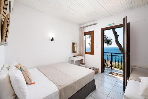 a bedroom with a bed and a view of the ocean at Acroterra - Easy Living in Alyki