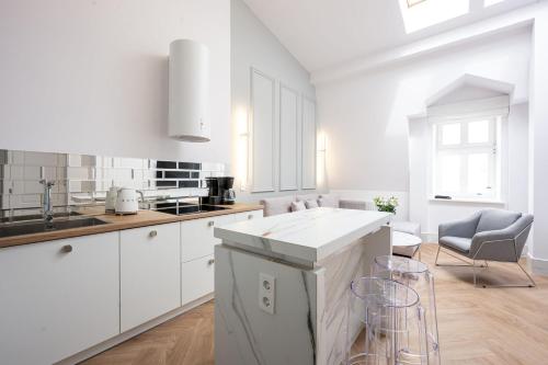 a white kitchen with a sink and a counter at Native Apartments Starowiślna 43/16 in Krakow