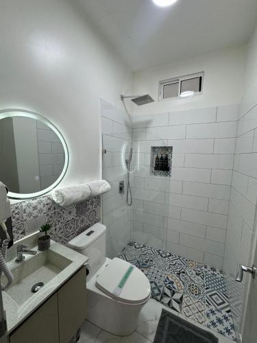 een witte badkamer met een toilet en een wastafel bij Apartaestudio La Capital in San José