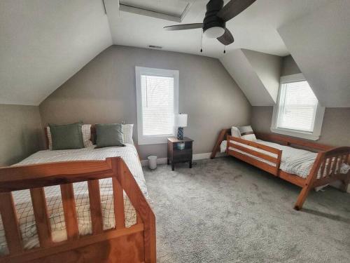 una camera mansardata con 2 letti e un ventilatore a soffitto di Sweet Cottage near Downtown DSM a Des Moines