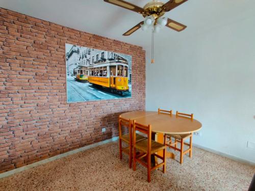 ein Esszimmer mit einem Tisch und einer Ziegelwand in der Unterkunft Piso cerca Playa con 2 duchas y 5 Aires Acondicionados in Almería