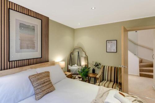 a bedroom with a bed and a chair and a staircase at City Stays Luxury Townhouse in Canterbury, sleeps 6 in Canterbury