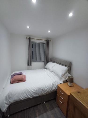 a bedroom with a large bed with white sheets at Beautiful maisonette in Leeds