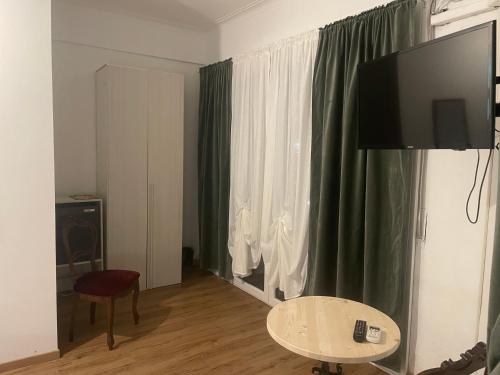 sala de estar con TV, mesa y ventana en B&B Cavour16, en Génova