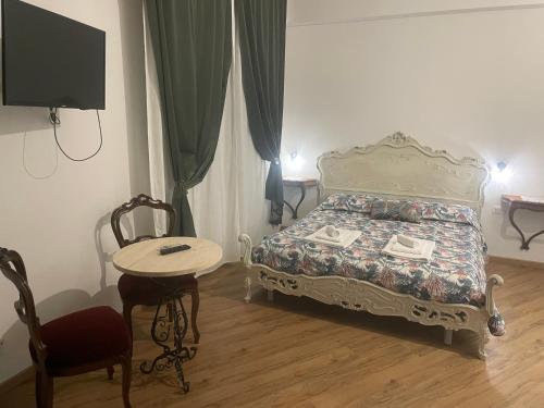 a bedroom with a bed and a table and a tv at B&B Cavour16 in Genoa